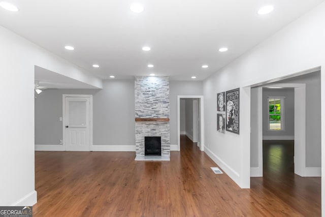 unfurnished living room with a fireplace, visible vents, wood finished floors, and recessed lighting