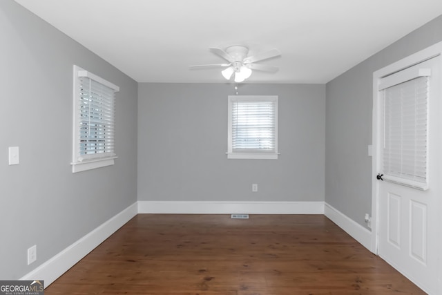 spare room featuring ceiling fan, wood finished floors, visible vents, and baseboards