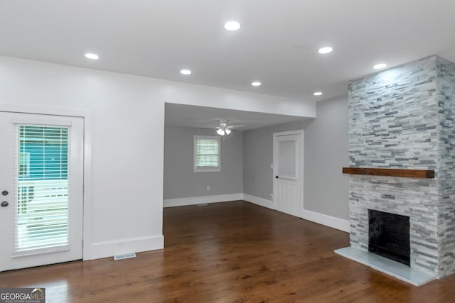 unfurnished living room featuring ceiling fan, a stone fireplace, wood finished floors, and recessed lighting