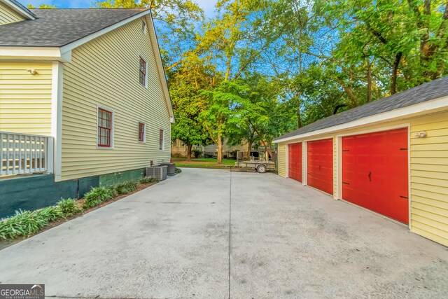 view of side of home with central AC unit, an outdoor structure, and a garage