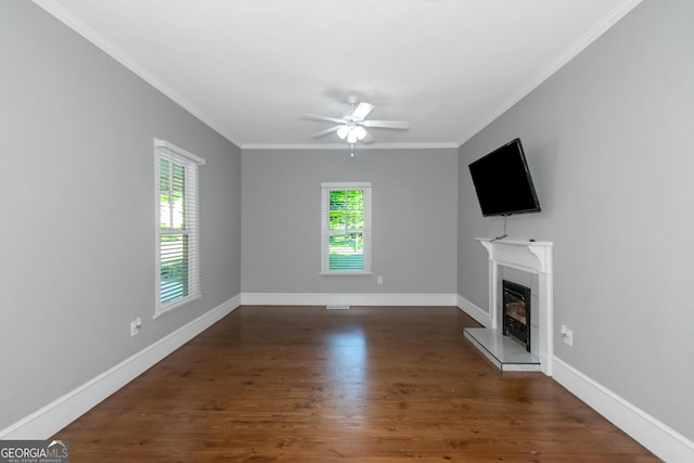 unfurnished living room with ornamental molding, wood finished floors, a glass covered fireplace, and baseboards