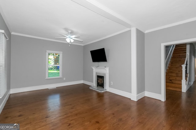 unfurnished living room with crown molding, baseboards, a fireplace with raised hearth, and wood finished floors