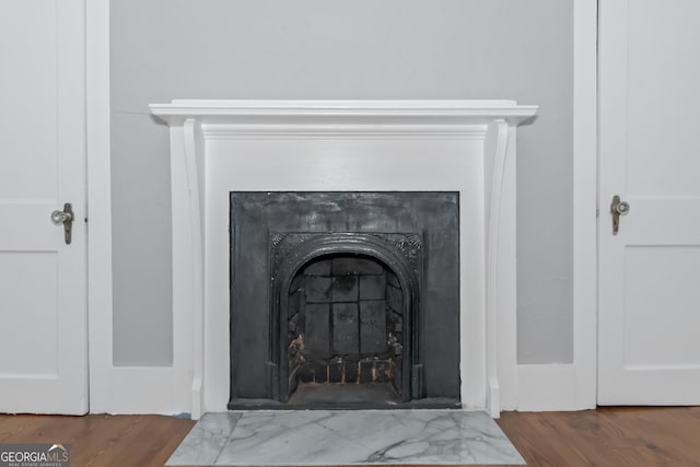 room details with a fireplace with flush hearth and wood finished floors