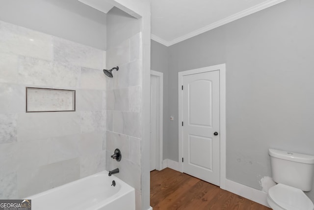 full bathroom featuring shower / bathtub combination, toilet, wood finished floors, baseboards, and ornamental molding