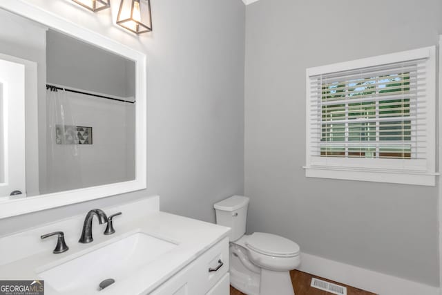 bathroom with curtained shower, visible vents, toilet, vanity, and baseboards