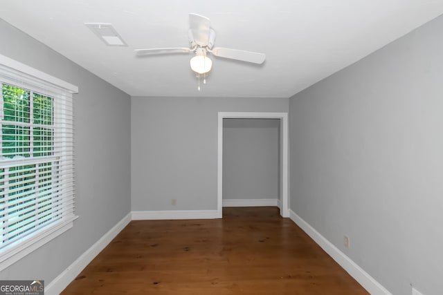 empty room featuring visible vents, ceiling fan, baseboards, and wood finished floors