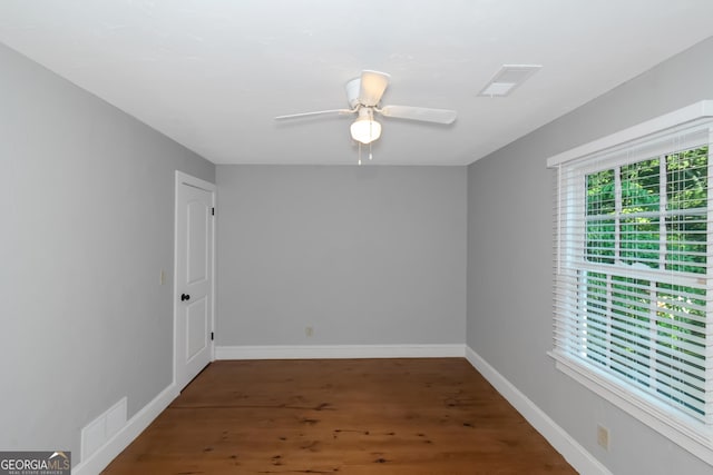 spare room with baseboards, visible vents, a ceiling fan, and wood finished floors