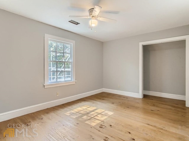 unfurnished bedroom featuring light wood-style floors, baseboards, and a ceiling fan