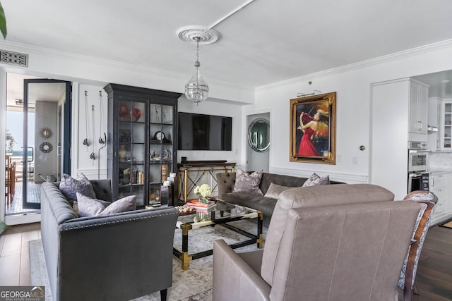 living area featuring ornamental molding, visible vents, and wood finished floors