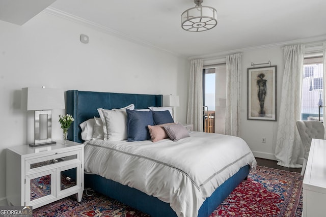 bedroom with crown molding, baseboards, and wood finished floors