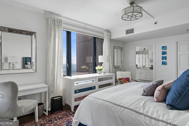 bedroom with ornamental molding, visible vents, and ensuite bathroom