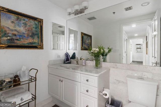 bathroom featuring toilet, visible vents, and vanity