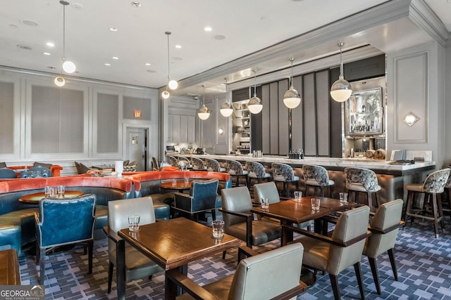 dining area featuring ornamental molding, recessed lighting, dark carpet, and a decorative wall