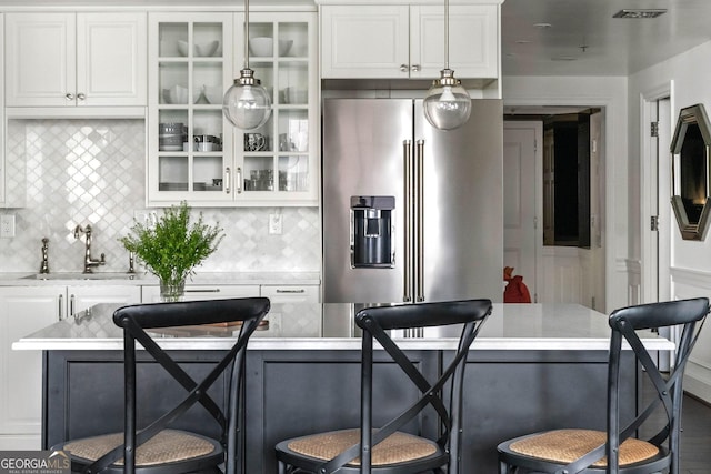 kitchen with a kitchen bar, glass insert cabinets, and light countertops