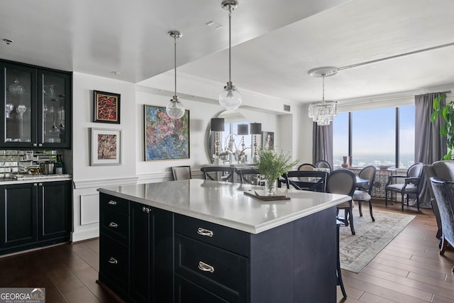 kitchen with light countertops, a kitchen breakfast bar, and dark cabinetry