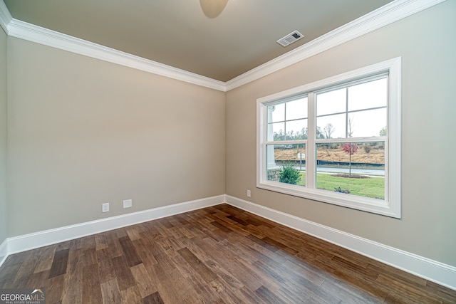 spare room with ornamental molding and dark hardwood / wood-style floors