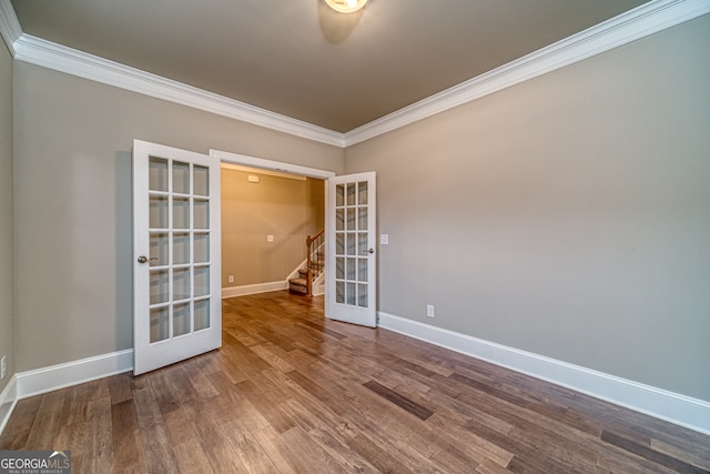 empty room with crown molding, hardwood / wood-style flooring, and french doors