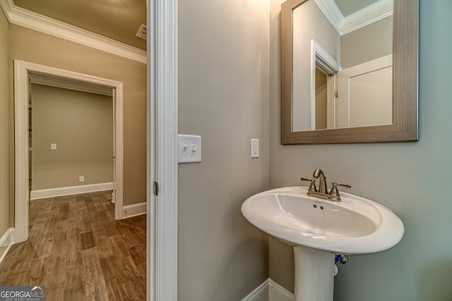 bathroom featuring crown molding and hardwood / wood-style floors