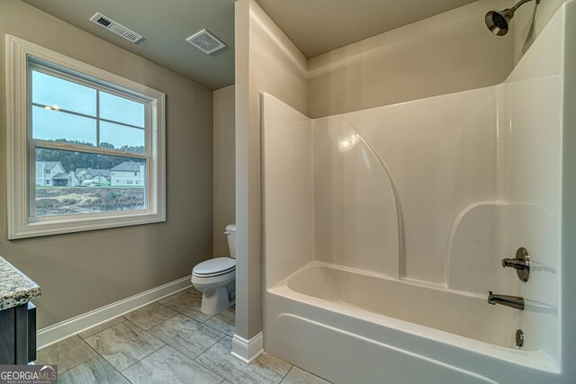 full bathroom with tile patterned floors, vanity, washtub / shower combination, and toilet