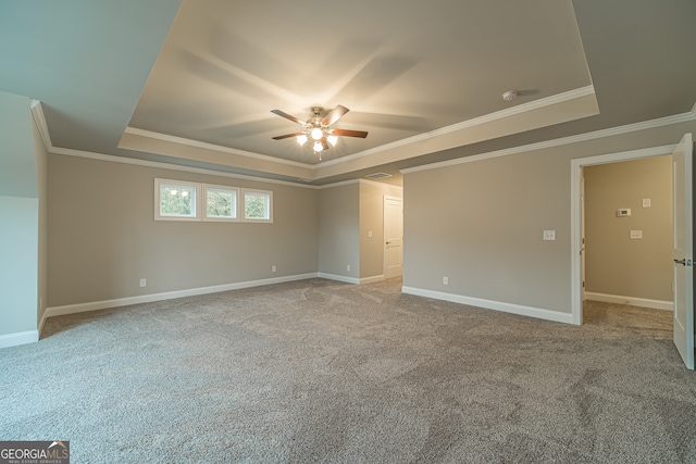 carpeted spare room featuring ceiling fan, a raised ceiling, and ornamental molding