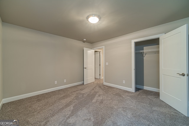 unfurnished bedroom featuring light carpet and a closet