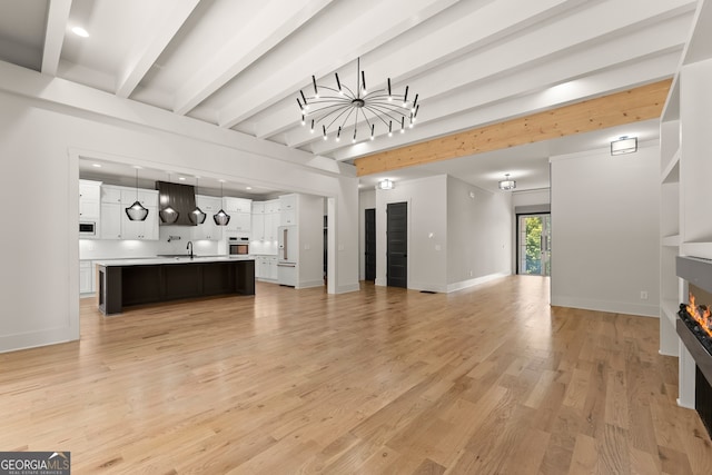 living room featuring beam ceiling and light hardwood / wood-style flooring