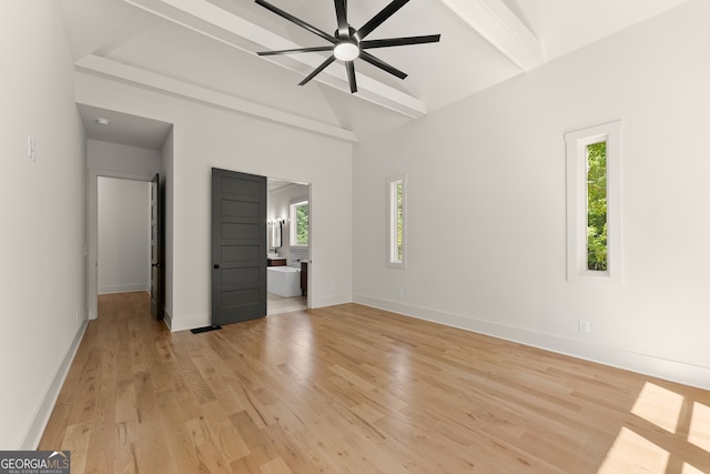 unfurnished bedroom featuring light wood-type flooring, lofted ceiling with beams, ensuite bath, and ceiling fan