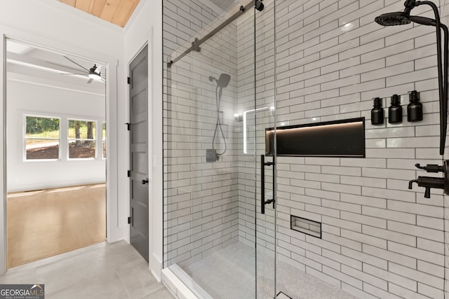 bathroom with ceiling fan, a shower with door, and crown molding