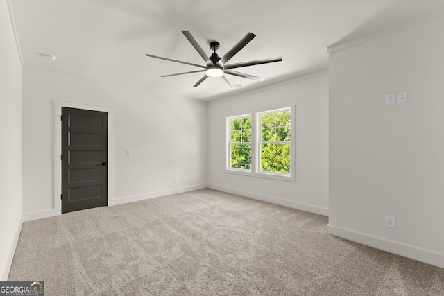 unfurnished room with ceiling fan, light colored carpet, and crown molding