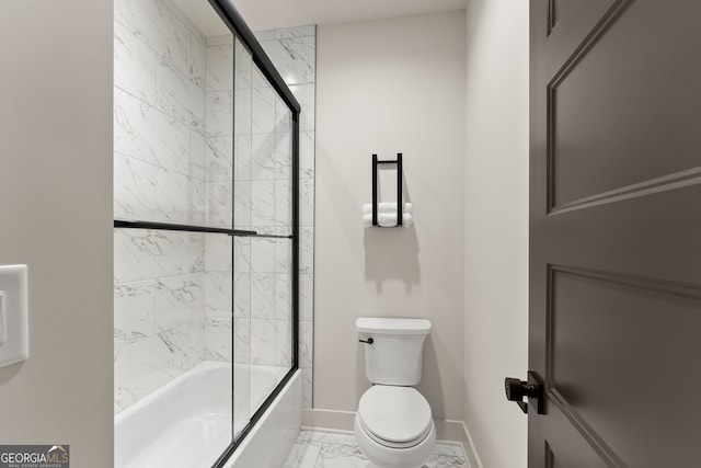 bathroom featuring enclosed tub / shower combo and toilet