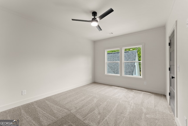 empty room featuring ceiling fan and light colored carpet