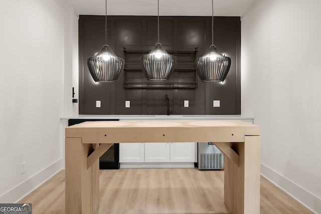 bar featuring light wood-type flooring and hanging light fixtures