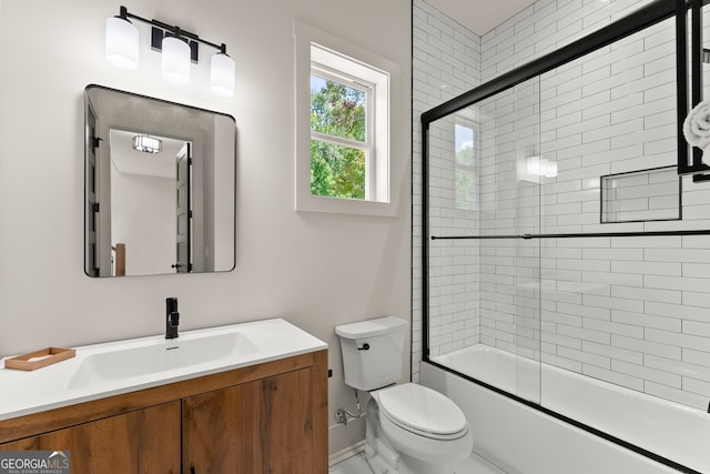 full bathroom featuring vanity, toilet, and bath / shower combo with glass door