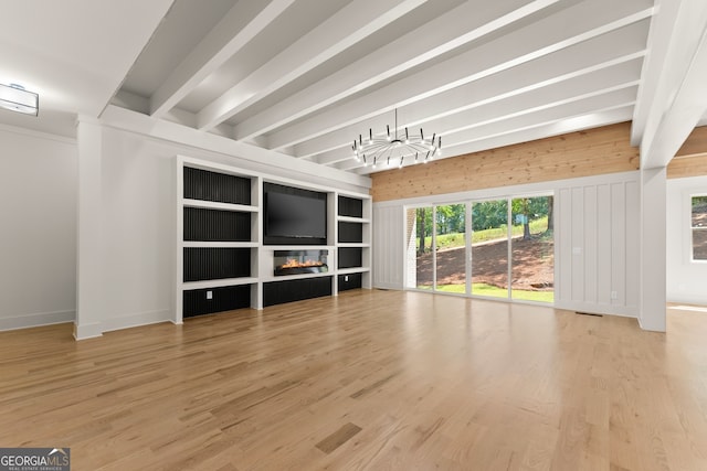 unfurnished living room featuring beamed ceiling, a chandelier, and hardwood / wood-style flooring