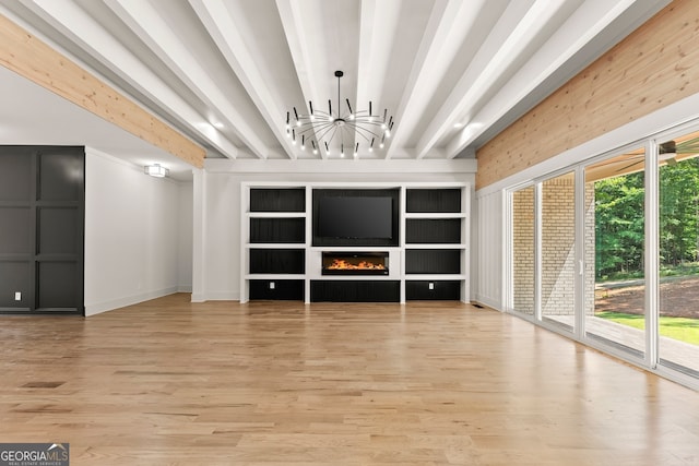 unfurnished living room with light wood-type flooring, a healthy amount of sunlight, and beam ceiling