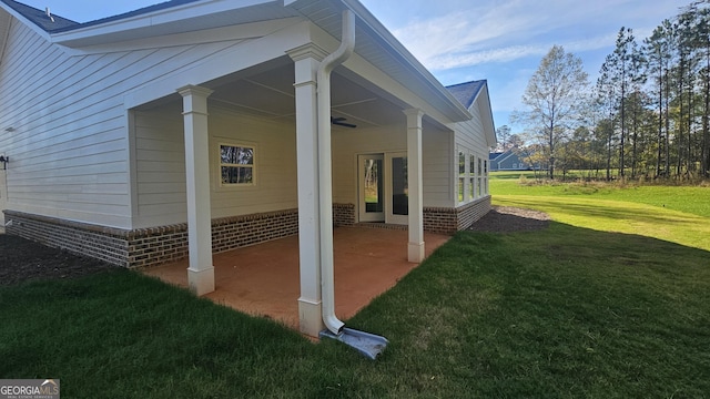 view of side of home with a patio area and a lawn