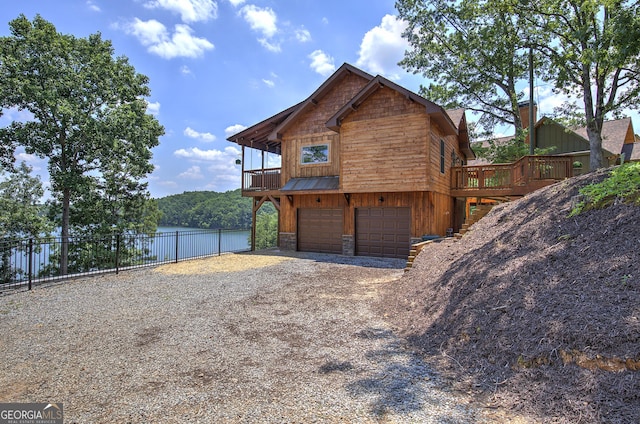 view of property exterior with a garage and a deck