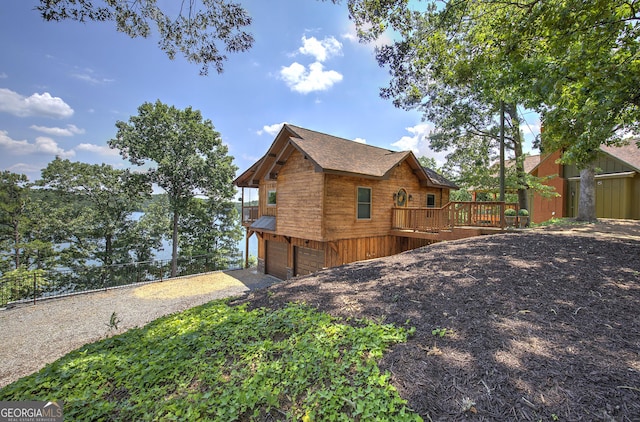 view of property exterior featuring a wooden deck and a garage