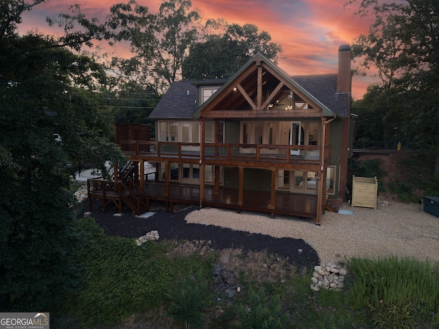 back house at dusk featuring a deck