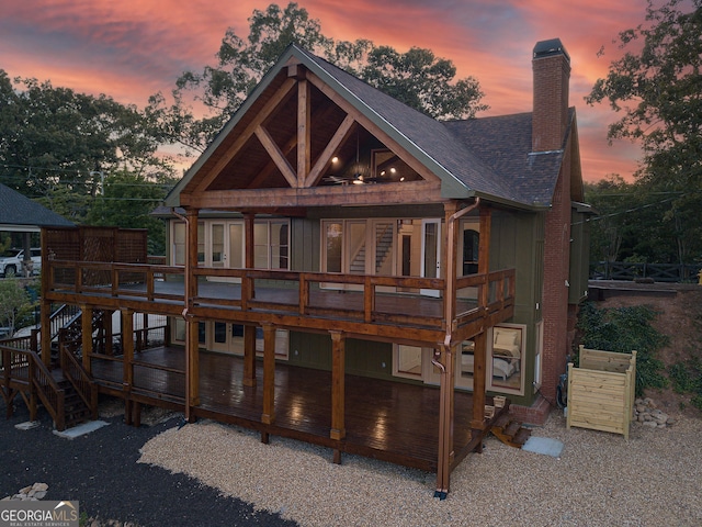 back house at dusk featuring a deck