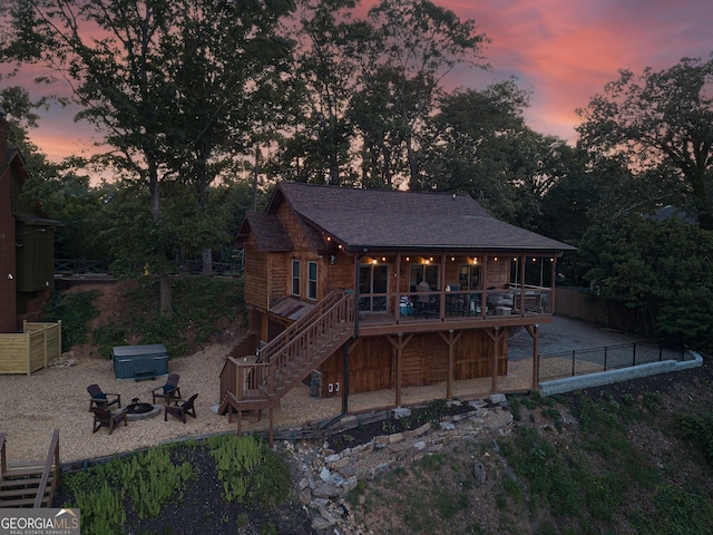 back house at dusk with a deck and an outdoor fire pit