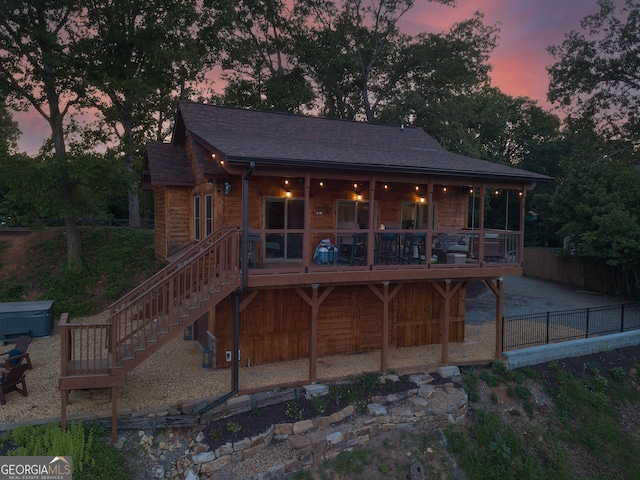 back house at dusk with a wooden deck