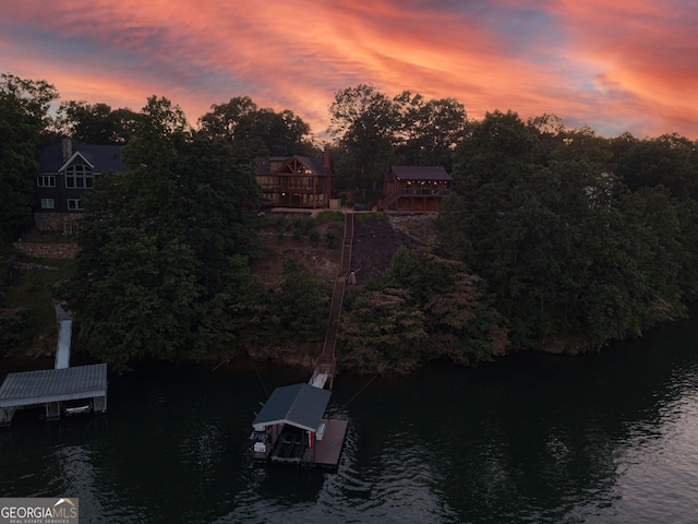 aerial view at dusk featuring a water view