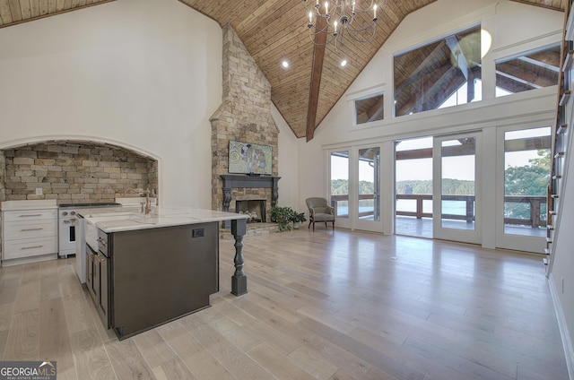 kitchen with wood ceiling, a fireplace, light hardwood / wood-style floors, and white cabinets