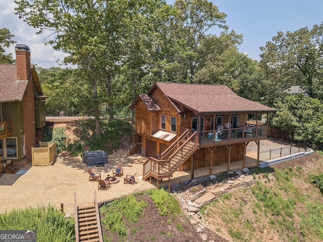 back of house with a wooden deck and an outdoor fire pit