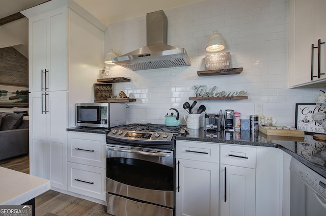 kitchen featuring white cabinetry, wood-type flooring, stainless steel appliances, and wall chimney exhaust hood