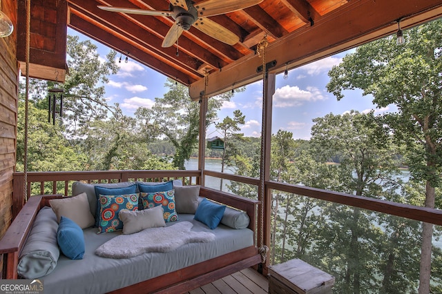 wooden deck with a water view, ceiling fan, and an outdoor living space