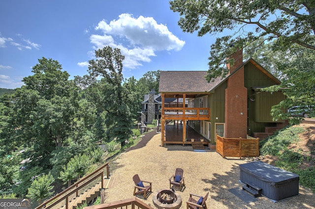 exterior space featuring a fire pit and a hot tub