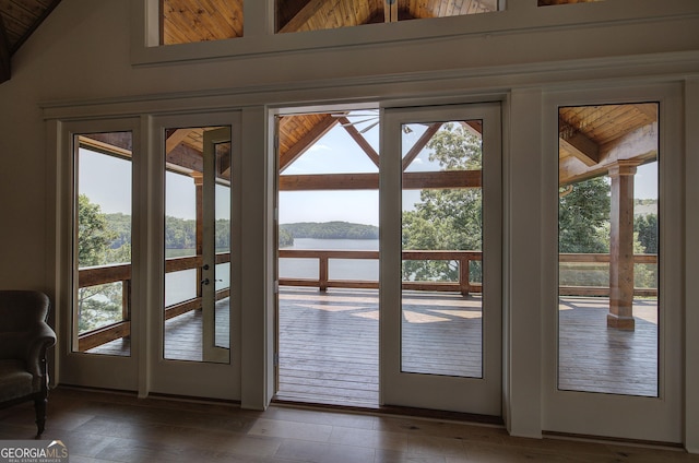 doorway featuring vaulted ceiling, a water view, and dark hardwood / wood-style flooring