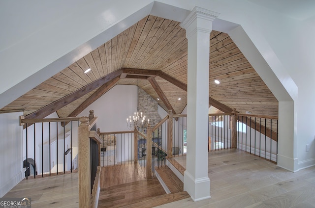 additional living space with ornate columns, beamed ceiling, light hardwood / wood-style floors, wooden ceiling, and an inviting chandelier